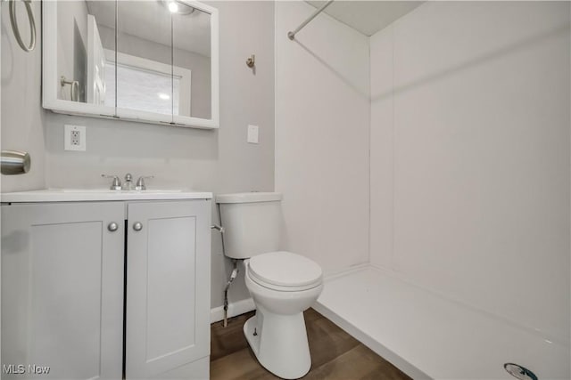 bathroom with vanity, hardwood / wood-style flooring, toilet, and walk in shower