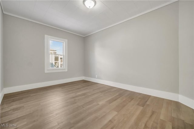 unfurnished room featuring crown molding and light wood-type flooring