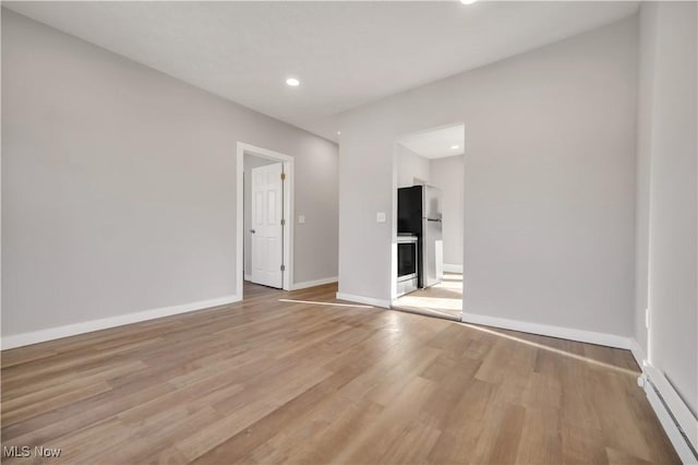 empty room featuring light hardwood / wood-style flooring and baseboard heating