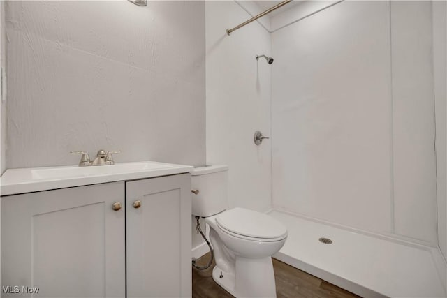 bathroom featuring vanity, hardwood / wood-style floors, toilet, and walk in shower