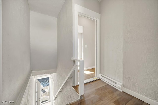 stairway featuring hardwood / wood-style flooring and a baseboard radiator