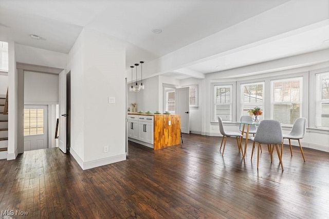 interior space with wooden counters, dark hardwood / wood-style flooring, hanging light fixtures, and white cabinets