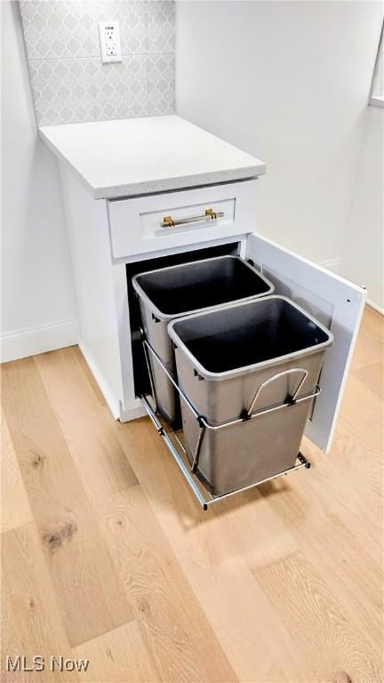 details featuring backsplash and light hardwood / wood-style flooring