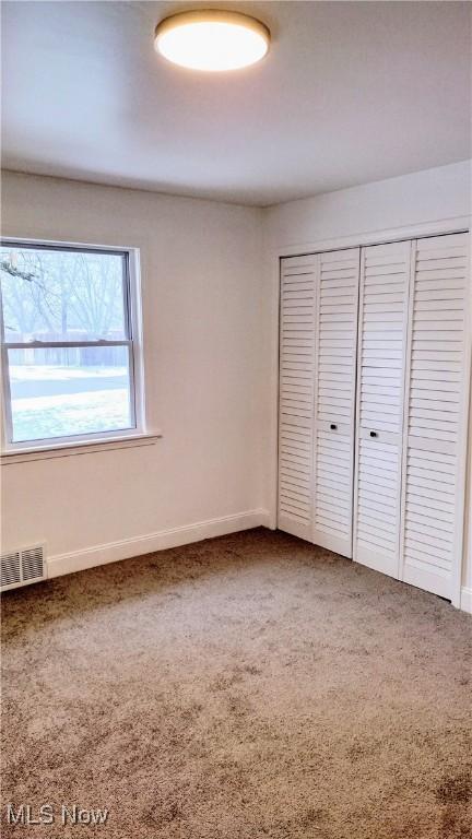 unfurnished bedroom featuring carpet and a closet