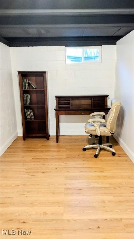 living area featuring beam ceiling and light hardwood / wood-style flooring