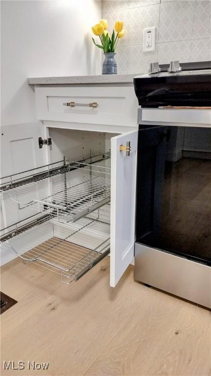 details featuring white cabinetry and light wood-type flooring