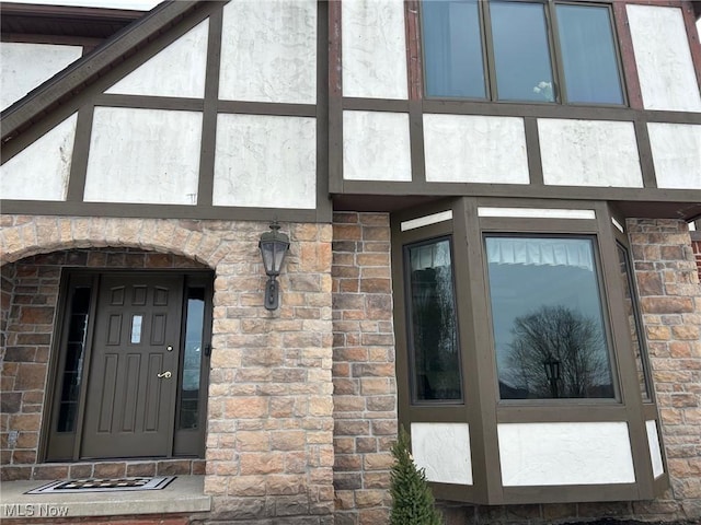 doorway to property with brick siding and stucco siding