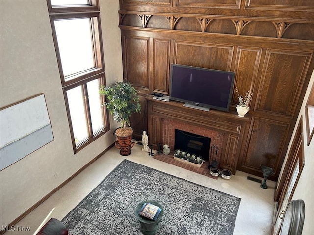 carpeted living room with a brick fireplace, baseboards, and a wealth of natural light