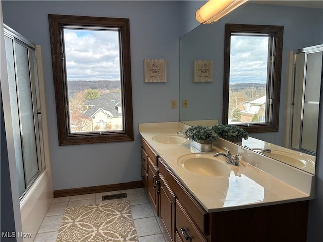 bathroom featuring tile patterned floors, vanity, combined bath / shower with glass door, and a wealth of natural light