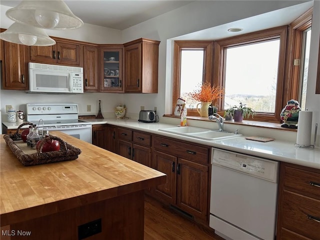 kitchen featuring dark wood-type flooring, white appliances, wood counters, and sink