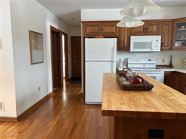 kitchen featuring white appliances, dark wood-style flooring, butcher block counters, baseboards, and glass insert cabinets