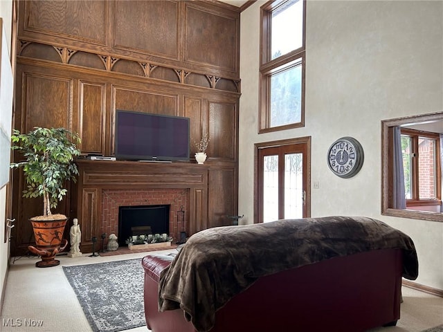 bedroom with carpet flooring, a fireplace, and a towering ceiling