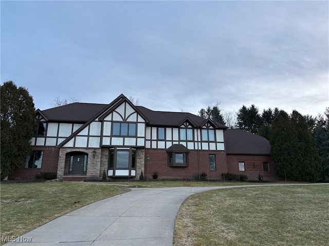 tudor-style house with a front yard and brick siding