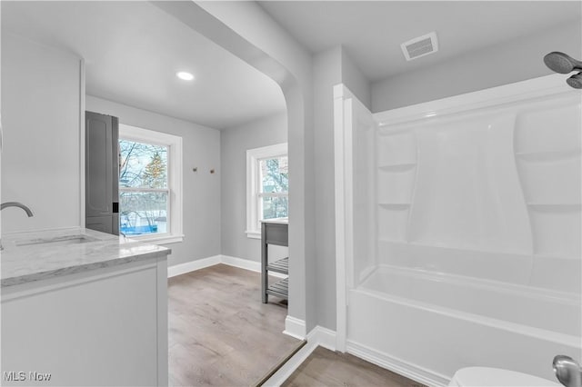 bathroom featuring vanity, hardwood / wood-style floors, and shower / bathing tub combination