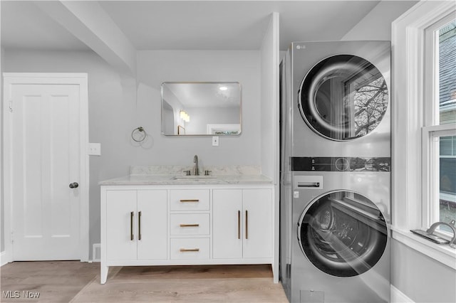 3295 Yorkshire Rd, Cleveland Heights, OH 44118 - laundry room with estacked washer and dryer, light wood-type flooring, cabinet space, and plenty of natural light