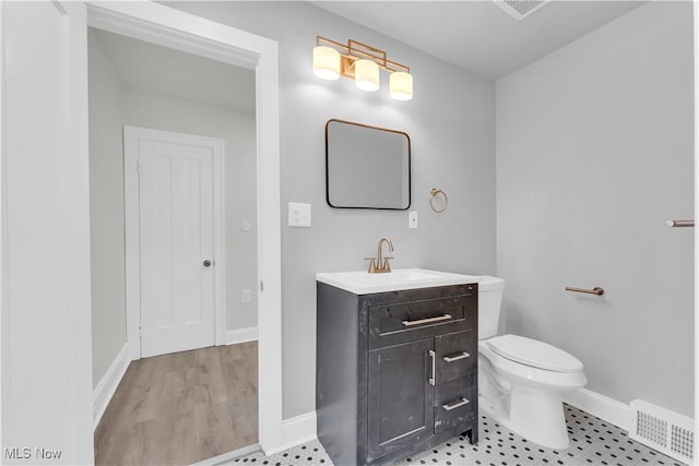 bathroom with vanity, hardwood / wood-style floors, and toilet