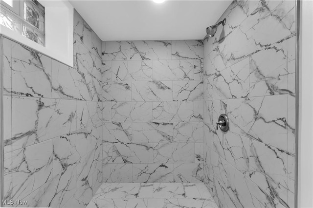 interior details featuring a tile shower
