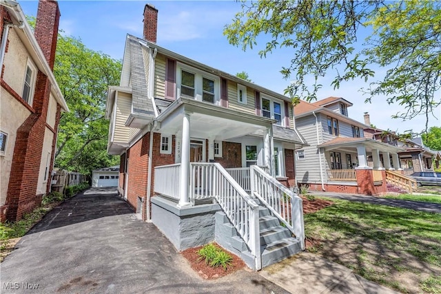 3295 Yorkshire Rd, Cleveland Heights, OH 44118 - view of front facade with an outbuilding, brick siding, a chimney, a detached garage, and covered porch