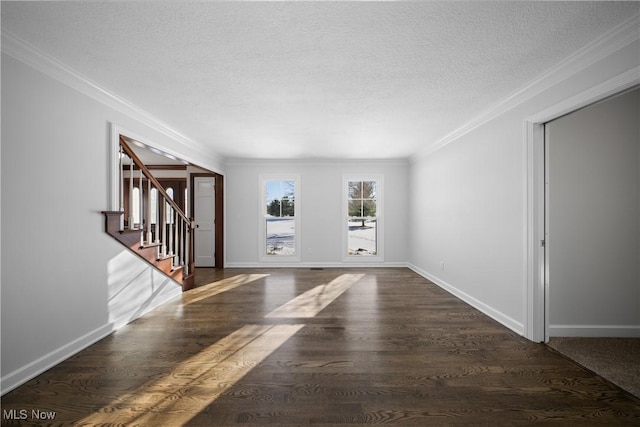 empty room featuring dark hardwood / wood-style flooring, ornamental molding, and a textured ceiling