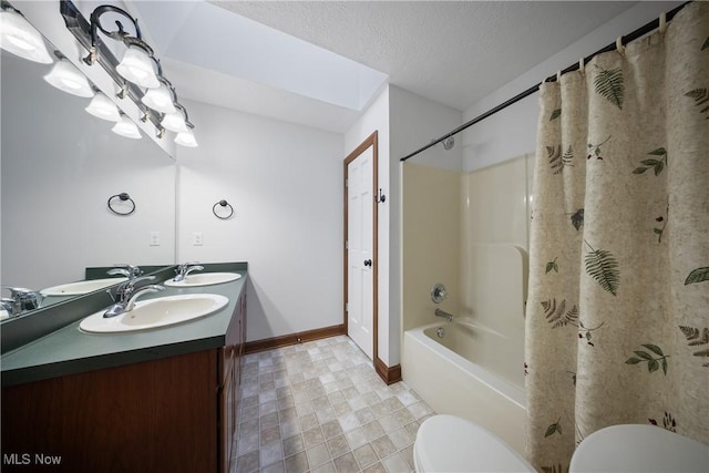 full bathroom featuring shower / tub combo with curtain, vanity, toilet, and a textured ceiling