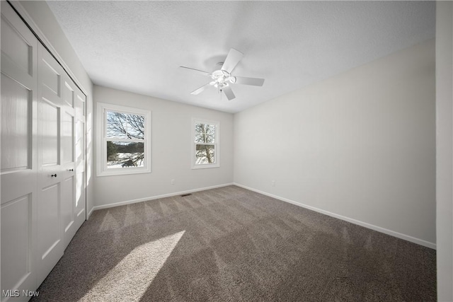 unfurnished bedroom with ceiling fan, a closet, a textured ceiling, and carpet