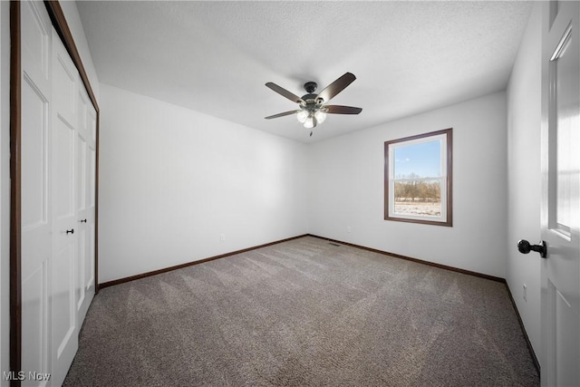 unfurnished bedroom with ceiling fan, carpet floors, a closet, and a textured ceiling