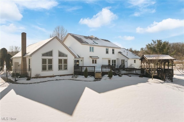 snow covered house featuring a deck