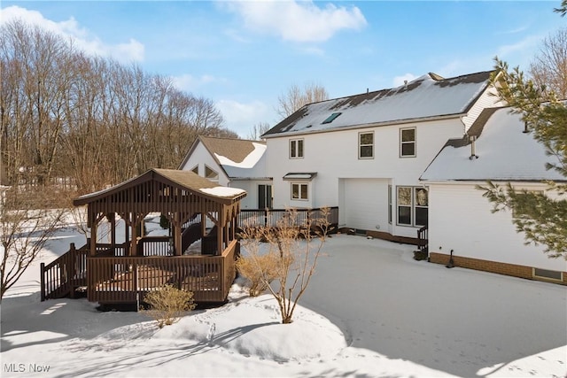 snow covered rear of property featuring a gazebo and a deck