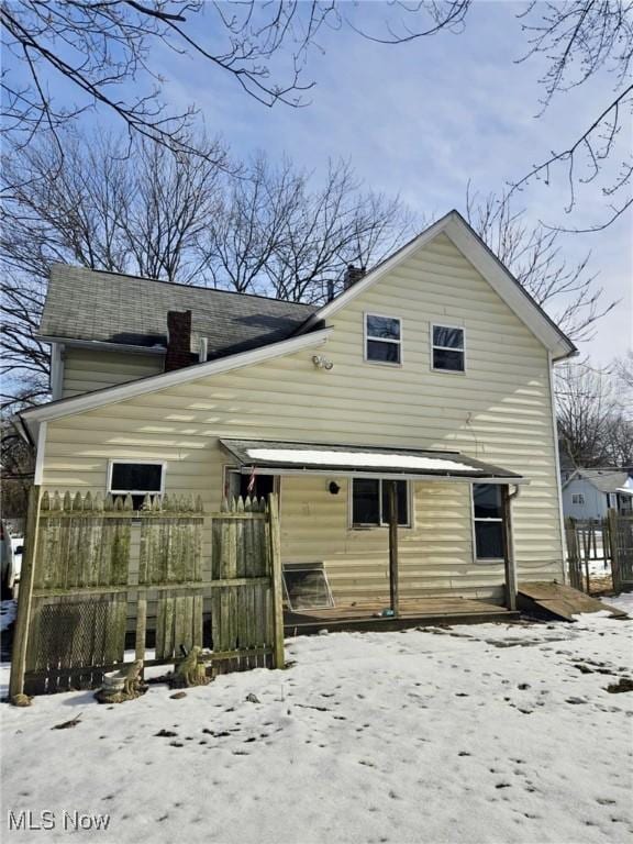 view of snow covered back of property