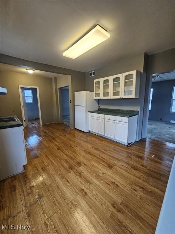 kitchen featuring white cabinetry, white fridge, and hardwood / wood-style flooring