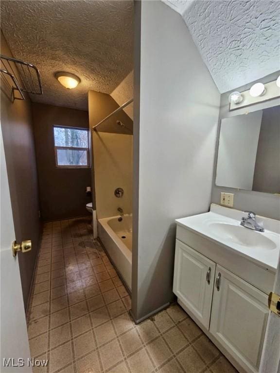 full bathroom with shower / tub combination, lofted ceiling, vanity, toilet, and a textured ceiling