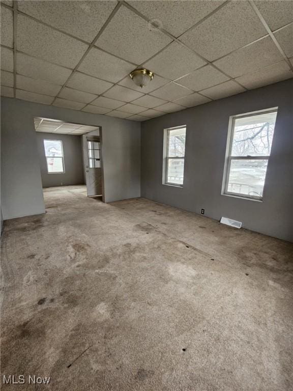 spare room with a drop ceiling and carpet floors