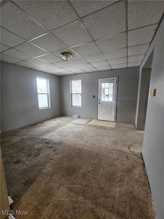 interior space with a paneled ceiling and carpet flooring