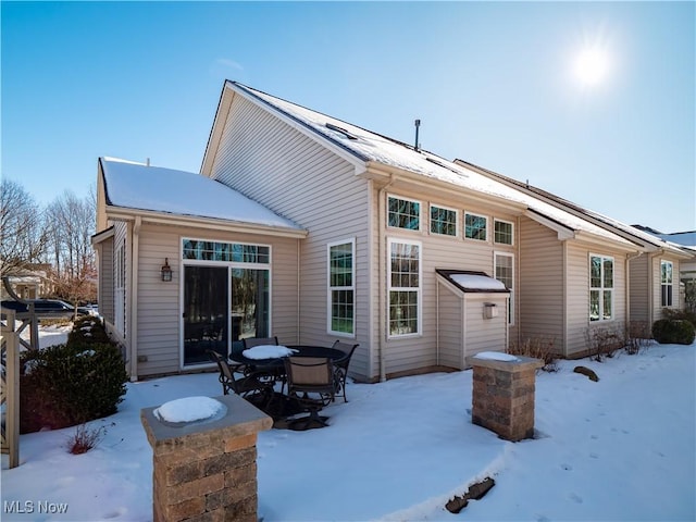 view of snow covered rear of property