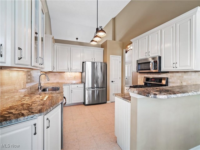 kitchen featuring dark stone countertops, sink, white cabinets, and appliances with stainless steel finishes