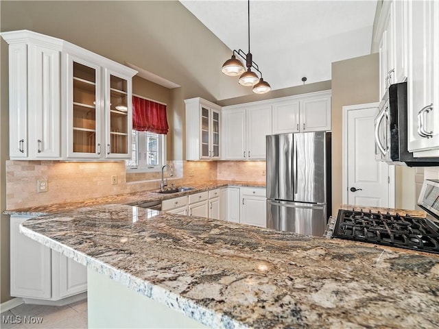 kitchen with appliances with stainless steel finishes, white cabinetry, sink, kitchen peninsula, and light stone countertops