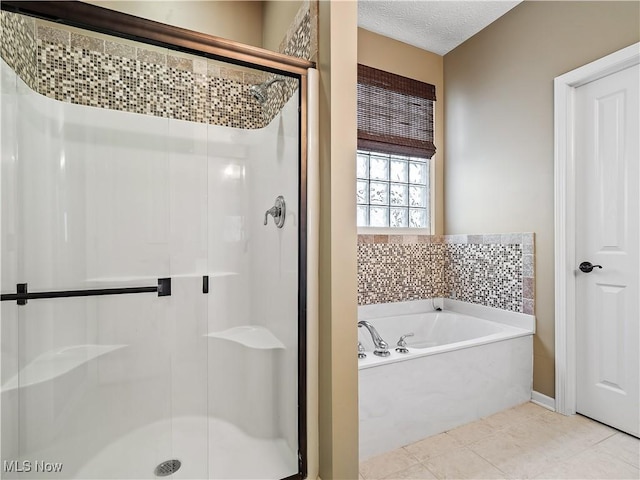 bathroom featuring tile patterned floors, independent shower and bath, and a textured ceiling