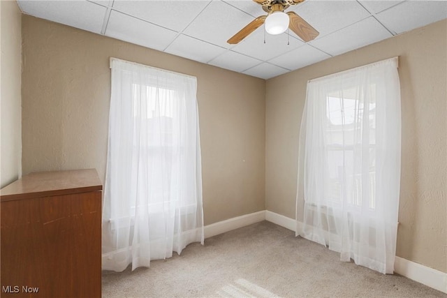 carpeted empty room featuring a paneled ceiling and ceiling fan