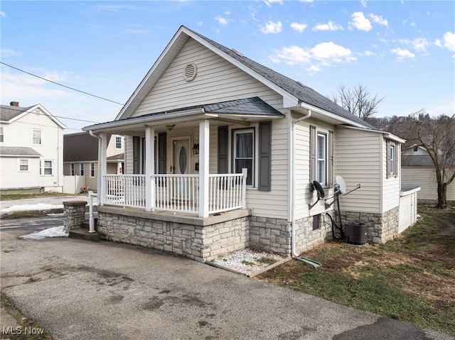 bungalow-style home featuring central AC unit and covered porch