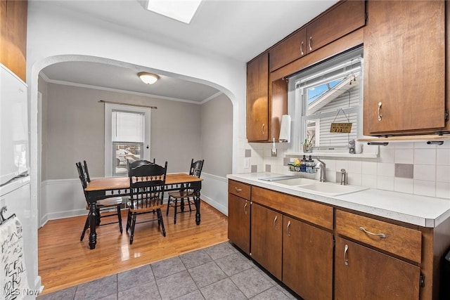 kitchen with a healthy amount of sunlight, sink, decorative backsplash, and light tile patterned floors