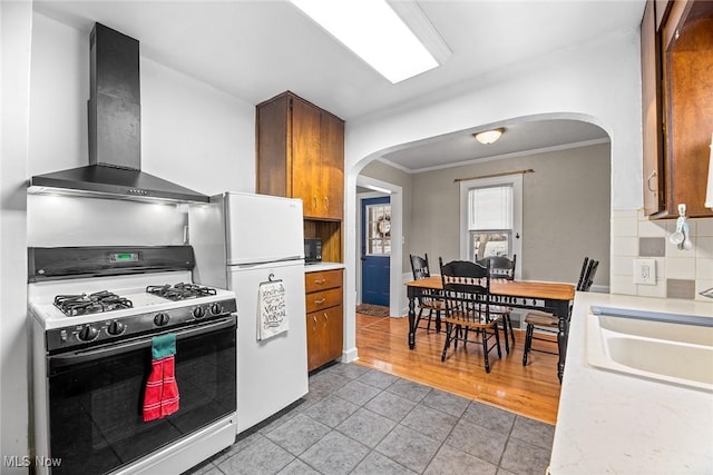 kitchen featuring range with gas cooktop, tasteful backsplash, sink, ornamental molding, and wall chimney range hood