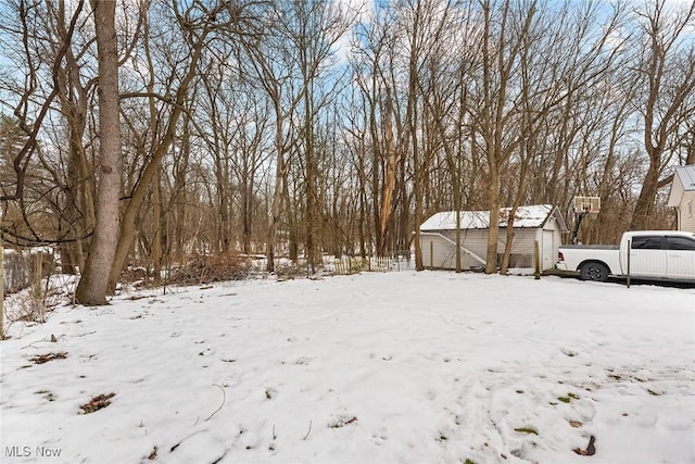 yard layered in snow featuring a storage shed