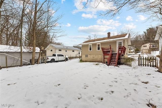 view of snow covered rear of property