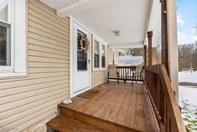 snow covered deck with covered porch