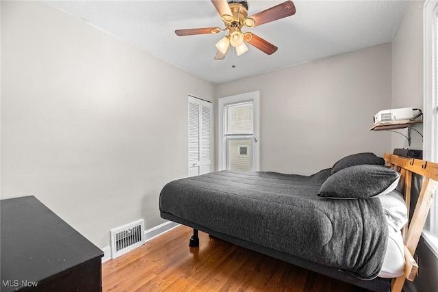 bedroom featuring wood-type flooring, ceiling fan, and a closet