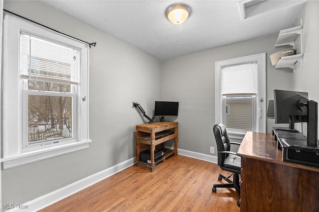 office space with light hardwood / wood-style floors and a textured ceiling