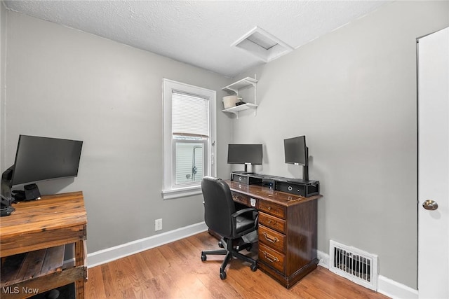 office area with a textured ceiling and light wood-type flooring