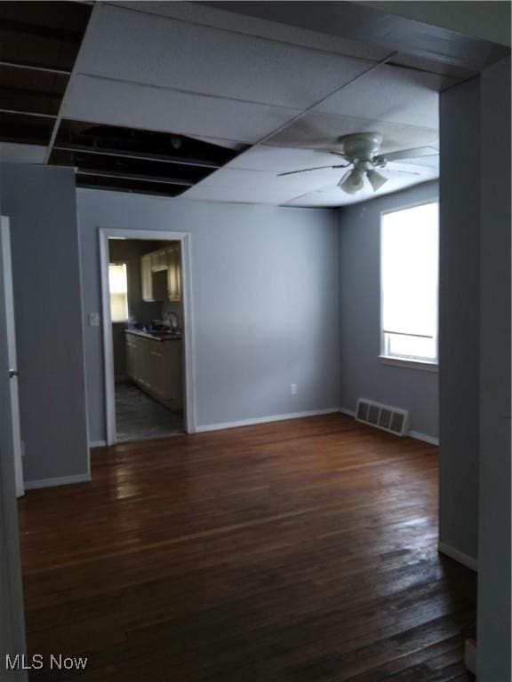 empty room featuring dark wood-type flooring and ceiling fan