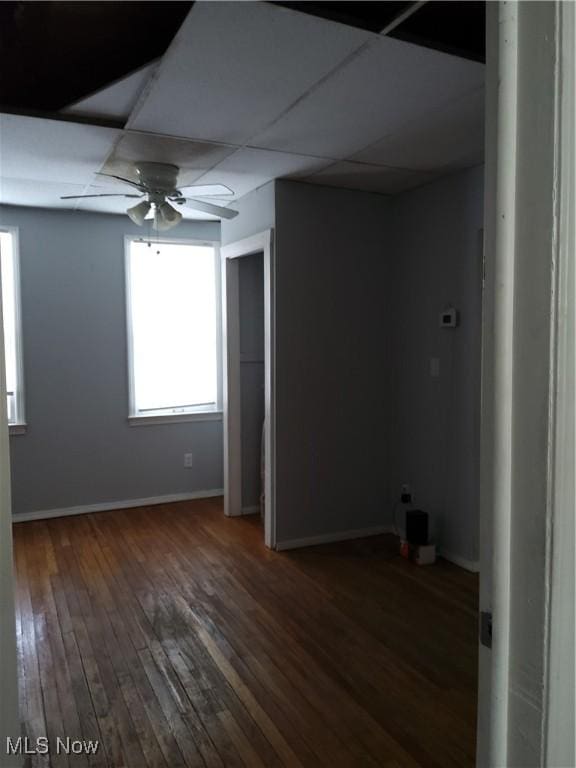 unfurnished room featuring dark hardwood / wood-style floors, a paneled ceiling, and ceiling fan