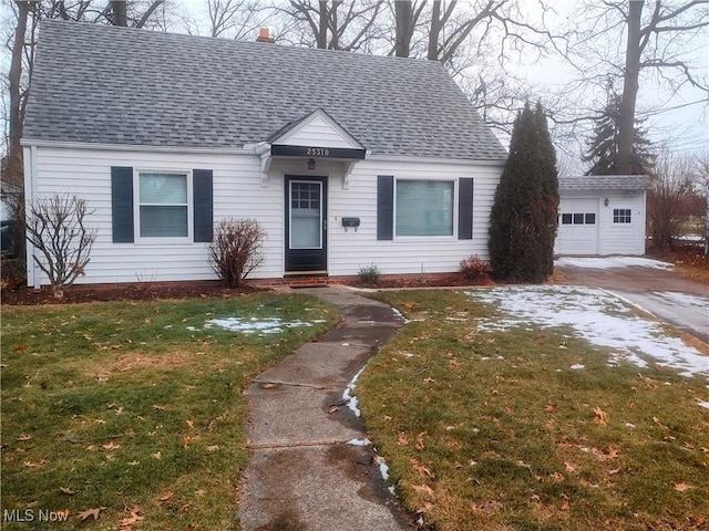 view of front of property featuring an outbuilding, a garage, and a front lawn